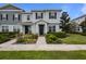 Charming townhome featuring a well-manicured front garden, stone accents, and a covered porch at 15430 Caravan Ave, Odessa, FL 33556
