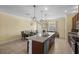 Spacious kitchen featuring a large island with a sink, a dining table, and ample cabinet space at 15430 Caravan Ave, Odessa, FL 33556