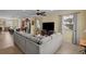 Open-concept living area featuring tile floors, a large sectional sofa, and kitchen access at 15430 Caravan Ave, Odessa, FL 33556