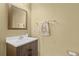 Tastefully decorated powder room features a vanity with a white countertop, a decorative mirror, and towel rack at 15430 Caravan Ave, Odessa, FL 33556