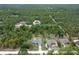 An aerial shot showing a grey roofed home surrounded by dense forest at 16473 Scaup Duck Ave, Weeki Wachee, FL 34614