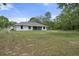 Spacious backyard featuring lush green grass and a screened patio, perfect for outdoor relaxation at 16473 Scaup Duck Ave, Weeki Wachee, FL 34614