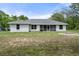 Backyard view of the home showcasing a well-maintained lawn and fire pit area at 16473 Scaup Duck Ave, Weeki Wachee, FL 34614