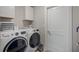 Functional laundry room featuring modern appliances and storage cabinets at 16473 Scaup Duck Ave, Weeki Wachee, FL 34614