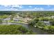 Aerial view of the home and surrounding neighborhood with waterfront access, mature trees, and manicured lawns at 1721 Allens Creek Dr, Clearwater, FL 33764