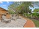 An outdoor patio provides a comfortable area for relaxation and entertainment among lush, mature landscaping at 1721 Allens Creek Dr, Clearwater, FL 33764