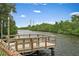 Private dock overlooking tranquil waters, surrounded by lush greenery, with seating for enjoying the view at 1721 Allens Creek Dr, Clearwater, FL 33764