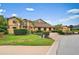 Exterior elevation of a well-maintained home with a brick driveway, lush landscaping, and mature trees at 1721 Allens Creek Dr, Clearwater, FL 33764