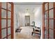 Bright foyer with decorative glass front door, travertine floors, and wood framed glass doors at 1721 Allens Creek Dr, Clearwater, FL 33764