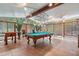 Well-lit game room boasting a pool table, foosball table, large windows, and terracotta tile flooring at 1721 Allens Creek Dr, Clearwater, FL 33764