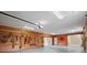 Spacious wood-paneled garage with ample storage and workspace featuring tools and yard equipment neatly organized at 1721 Allens Creek Dr, Clearwater, FL 33764
