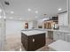 Spacious kitchen featuring a large island, white cabinets, stainless appliances, and travertine floors at 1721 Allens Creek Dr, Clearwater, FL 33764