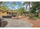 The paved outdoor space has various entertainment zones with a fountain, built-in grill, and lounging area at 1721 Allens Creek Dr, Clearwater, FL 33764