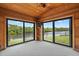 Bright sunroom with wood-paneled walls, carpet floors and large glass doors with a scenic view of the water at 1721 Allens Creek Dr, Clearwater, FL 33764