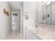 Bathroom with white cabinets, marble countertop and shower with hallway and pool access at 1839 Neptune Dr, Englewood, FL 34223