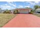 Beautiful single-story home with a spacious driveway and a well-manicured lawn under a partly cloudy sky at 1839 Neptune Dr, Englewood, FL 34223