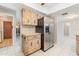 Bright kitchen featuring a stainless steel refrigerator and wood-look cabinets at 1839 Neptune Dr, Englewood, FL 34223