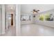Bright living room with tile floors, ceiling fan, and view of lush greenery at 1839 Neptune Dr, Englewood, FL 34223