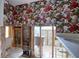 Bathroom with floral wallpaper, exposed walls, and toilet and sink needing renovation at 1897 Dolphin S Blvd, St Petersburg, FL 33707
