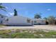 Charming single-story home with a brick facade, large driveway, and well-maintained landscaping under a clear blue sky at 1897 Dolphin S Blvd, St Petersburg, FL 33707