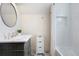 Bright bathroom featuring a tiled shower with a niche and a classic vanity with a round mirror at 1915 10Th N St, St Petersburg, FL 33704