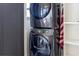 A stacked washer and dryer set with modern features and an American flag nearby at 1915 10Th N St, St Petersburg, FL 33704