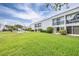 Spacious backyard featuring lawn, community shuffleboard, and condo buildings with balconies at 2060 Marilyn St # 114, Clearwater, FL 33765