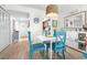 Bright dining area features blue chairs, white table, and views of the kitchen and hallway, exuding coastal charm at 2060 Marilyn St # 114, Clearwater, FL 33765