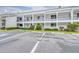 Exterior view of condo with a guest parking area and well-maintained landscaping at 2060 Marilyn St # 114, Clearwater, FL 33765