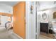 Hallway connecting the bedroom and bathroom with an orange accent wall and open doorways at 2060 Marilyn St # 114, Clearwater, FL 33765