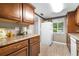 Kitchen with wood cabinets, white appliances, and ample counter space offers practicality and efficiency at 2060 Marilyn St # 114, Clearwater, FL 33765