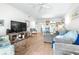 Spacious condo living room featuring a TV, modern furniture, and light wood floors at 2060 Marilyn St # 114, Clearwater, FL 33765