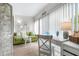 Cozy living room with green sofa, white desk, and ample natural light creates a relaxing and inviting atmosphere at 2060 Marilyn St # 114, Clearwater, FL 33765