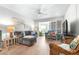 Comfortable condo living room with a plush couch, modern ceiling fan, and light wood floors at 2060 Marilyn St # 114, Clearwater, FL 33765