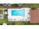 An aerial view of the community pool featuring ample seating, shuffleboard court, and lush green landscaping at 2060 Marilyn St # 114, Clearwater, FL 33765