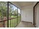 Balcony overlooking lawn with large trees, black metal railing and access to a storage area at 210 Martha Ln # 210, Oldsmar, FL 34677