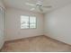 Neutral bedroom with standard closet, window, white ceiling fan and beige carpet at 210 Martha Ln # 210, Oldsmar, FL 34677