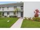 Inviting condo exterior with well-maintained lawn and path leading to the main entrance and lush landscaping at 210 Martha Ln # 210, Oldsmar, FL 34677