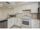 Updated kitchen with white cabinets, modern countertops, stainless steel dishwasher, and a microwave at 210 Martha Ln # 210, Oldsmar, FL 34677