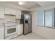 Compact kitchen featuring white cabinets, stainless steel appliances, and a window bringing in natural light at 210 Martha Ln # 210, Oldsmar, FL 34677