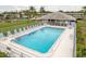 Large community pool surrounded by lounge chairs and mature landscaping with a nearby pool house at 210 Martha Ln # 210, Oldsmar, FL 34677