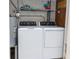 Laundry room with washer, dryer, water heater and overhead shelving at 241 Skiff Pt # 1, Clearwater Beach, FL 33767