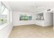 Bright living room featuring tile flooring, large windows, and a ceiling fan, creating a welcoming atmosphere at 241 Skiff Pt # 1, Clearwater Beach, FL 33767
