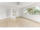 Spacious living area with tile floors, neutral decor, and access to outdoor areas through sliding doors and windows at 241 Skiff Pt # 1, Clearwater Beach, FL 33767