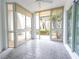 Bright sunroom featuring tile flooring and plenty of windows offering a view of the surrounding greenery at 241 Skiff Pt # 1, Clearwater Beach, FL 33767