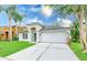 A well-maintained single-story home with an arched entryway, two-car garage, and lush front yard at 25729 Aldus Dr, Land O Lakes, FL 34639