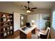 A sunny home office with a modern desk, built-in bookcase, and ample natural light at 25729 Aldus Dr, Land O Lakes, FL 34639