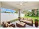 Cozy covered patio featuring a comfortable seating area and serene views of the landscaped backyard at 25729 Aldus Dr, Land O Lakes, FL 34639