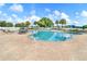 A community pool includes lounge chairs and shade umbrellas, with a playground in the background at 25729 Aldus Dr, Land O Lakes, FL 34639