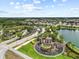 A picturesque aerial view of the community entrance, showcasing the water feature, landscaping, and surrounding homes and greenery at 2724 Coco Palm Cir, Wesley Chapel, FL 33543